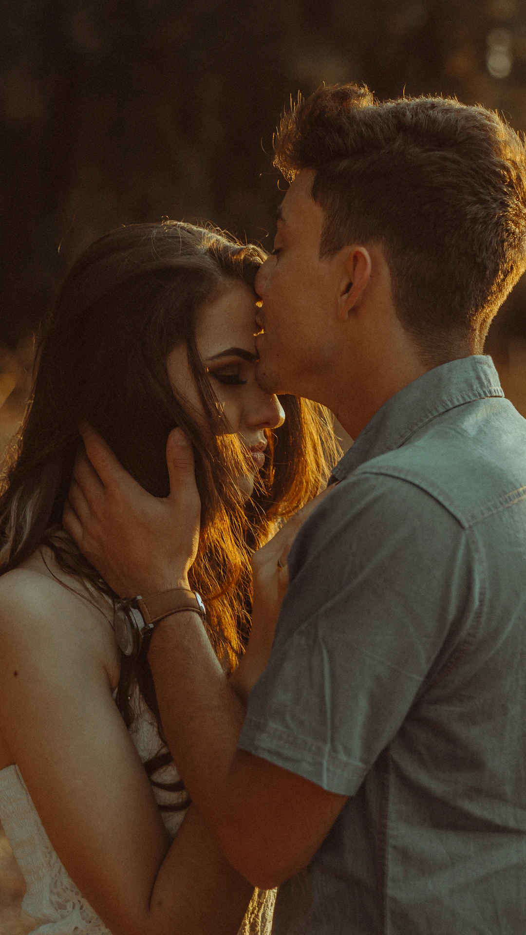 man kissing woman forehead