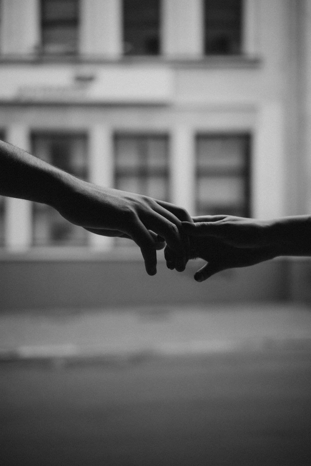 Artistic black and white image of two hands reaching out to each other, symbolizing connection.