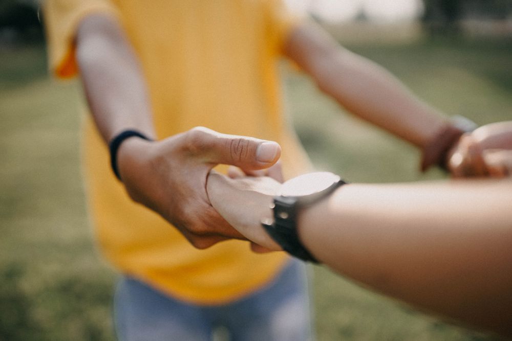 Intimate close-up of a couple holding hands, symbolizing love and togetherness.