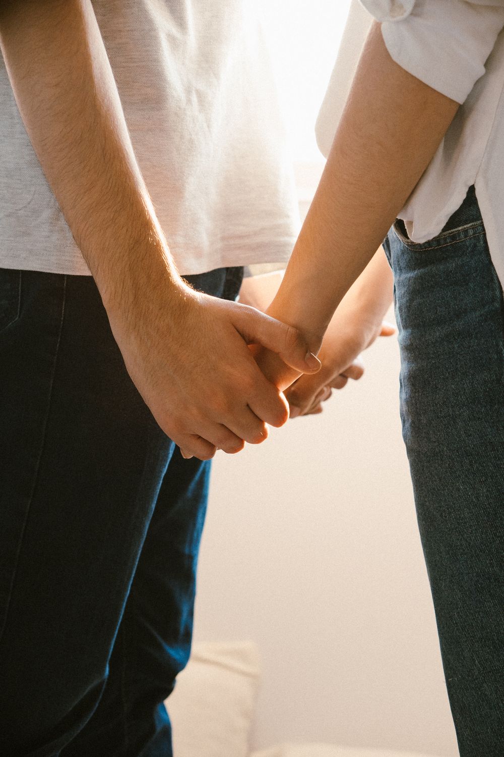 Close-up of a couple holding hands, expressing love and connection.