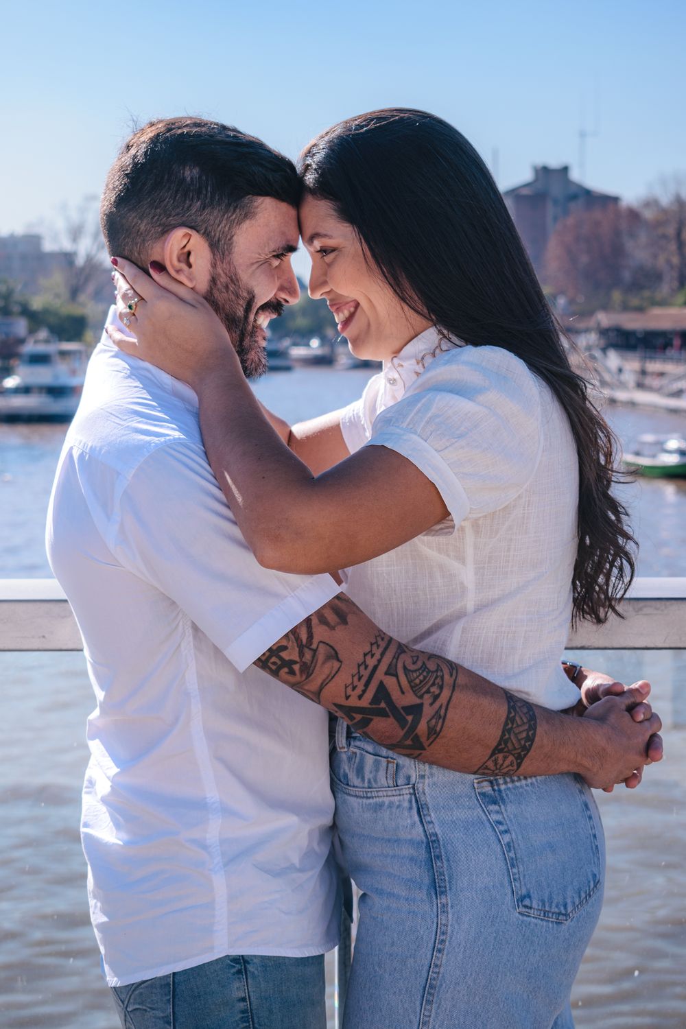 A joyful couple embraces by the river in Tigre, Buenos Aires, capturing a moment of love and happiness.